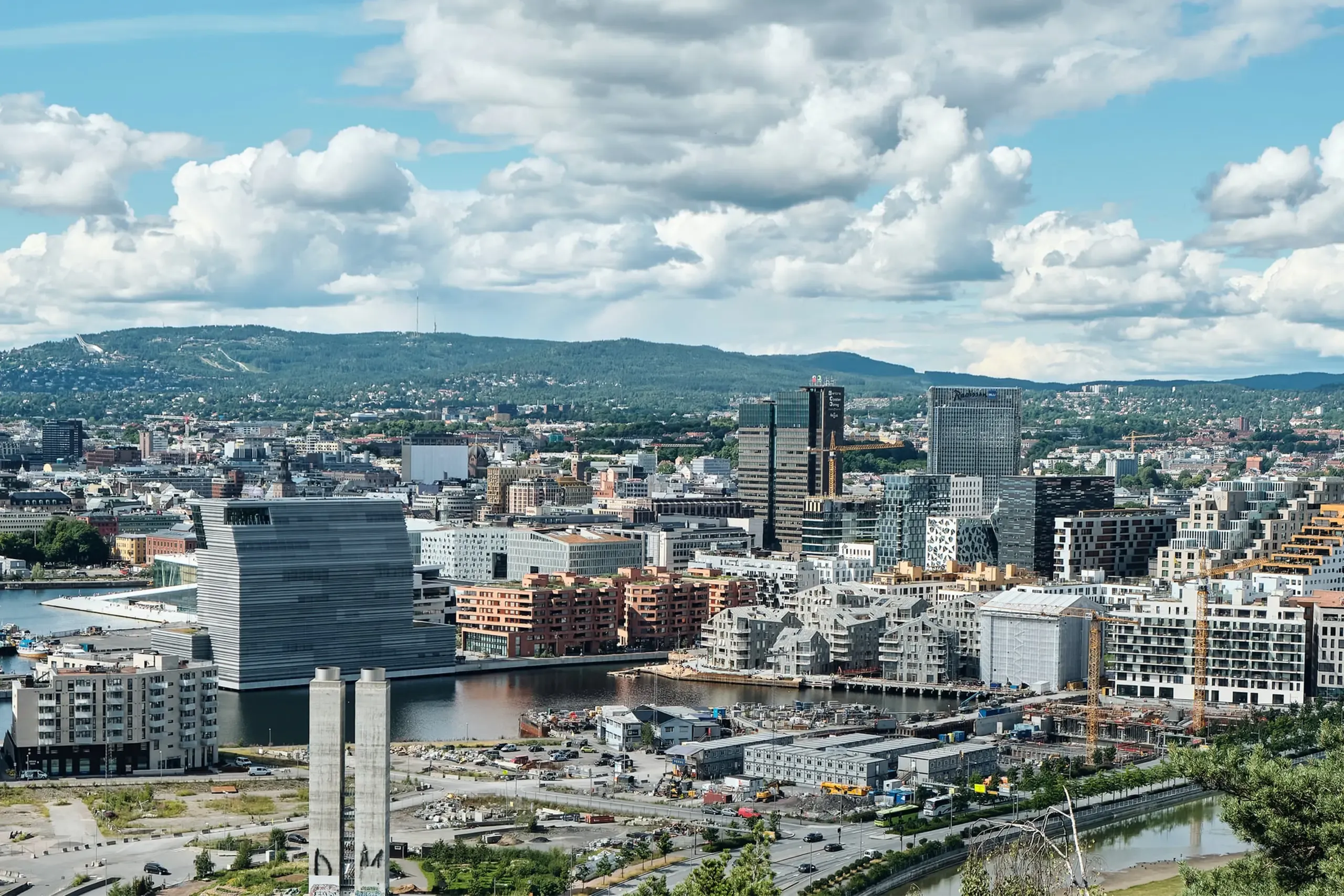 Bjørvika i Oslo sett fra øst, med Munchmuseet, Barcode og nye boligblokker langs vannet. Flere byggekraner står i området.